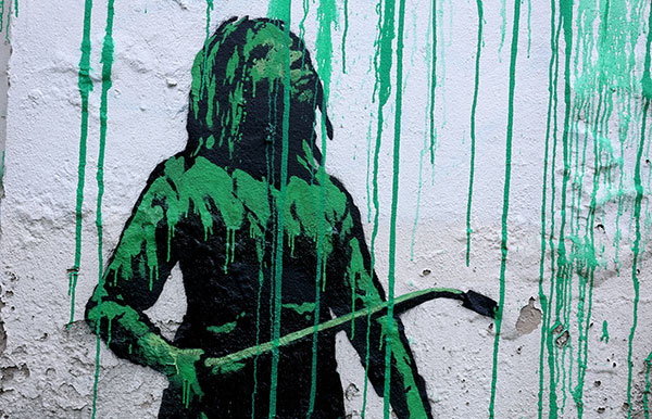 Detail of the figure by Banksy at the base of the tree