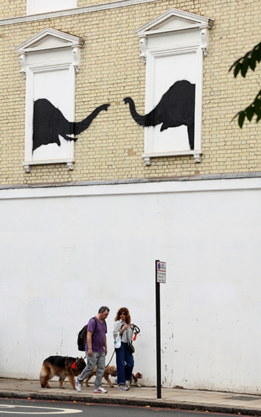Banksy's elephants reaching towards each other on the side of a house in Chelsea