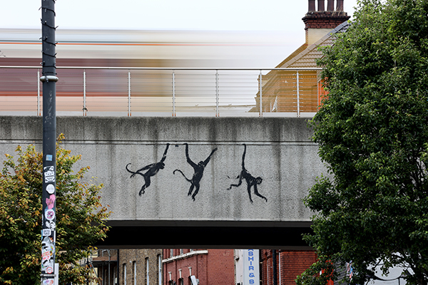 Banksy monkeys on a bridge on Brick Lane