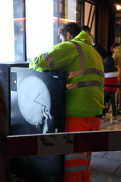Transport for London worker removing the Banksy artwork on a TFL junction box.