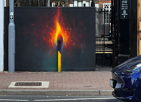 Irony burning match bollard street art in Kingston