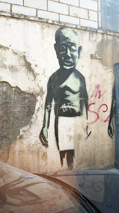 Mr Yu, painted figure in a side street off Brick Lane